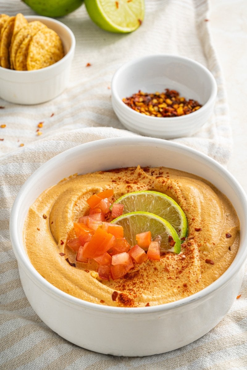 A bowl of vegan queso fresco with some chilis nearby