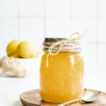 A jar of homemade honey lemon cough syrup and a spoon.