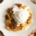 A serving of crock pot apple dump cake topped with ice cream.
