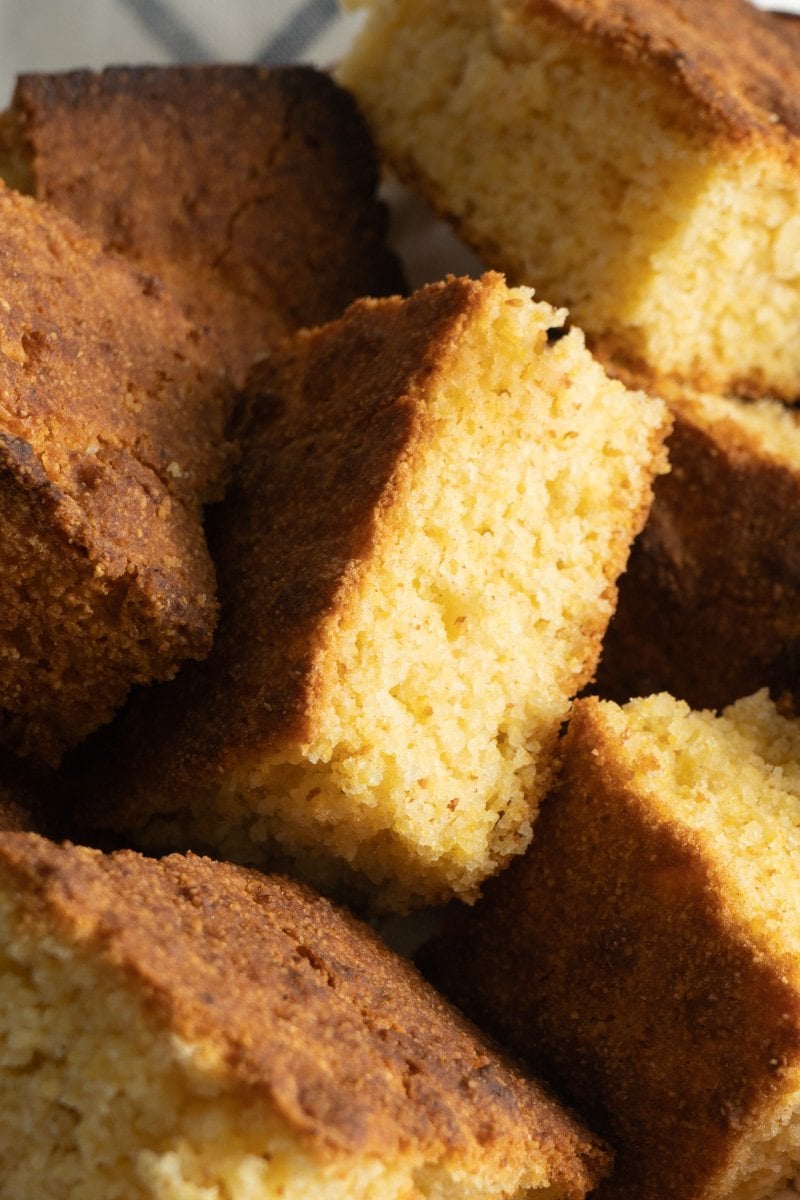 A close up of a piece of gluten free corn bread in a basket.