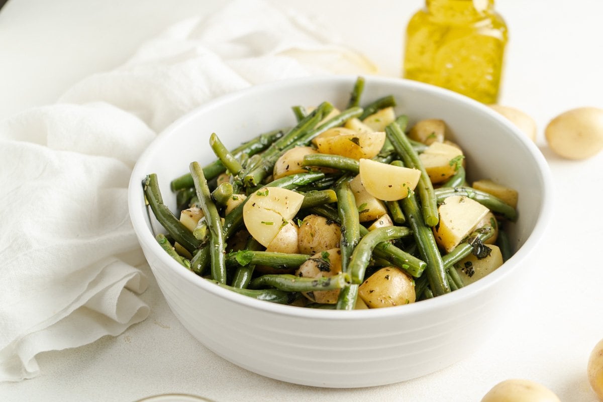 An easy green beans and potatoes recipe in a white bowl.