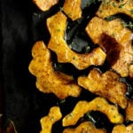 air fryer acorn squash on a piece of slate drizzled with maple syrup