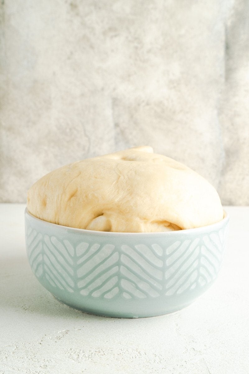 A large bowl of risen bread dough.