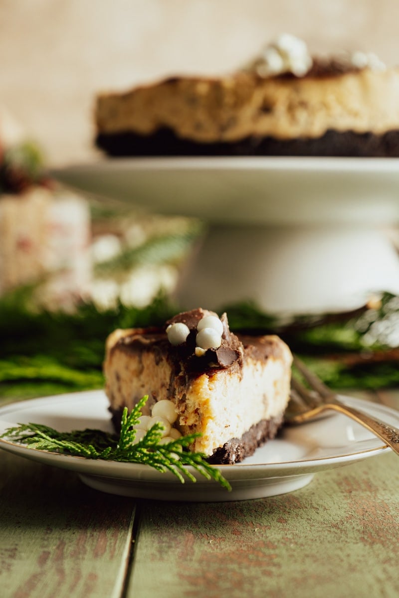 A slice of cheesecake made without sour cream on a plate with winter decorations.