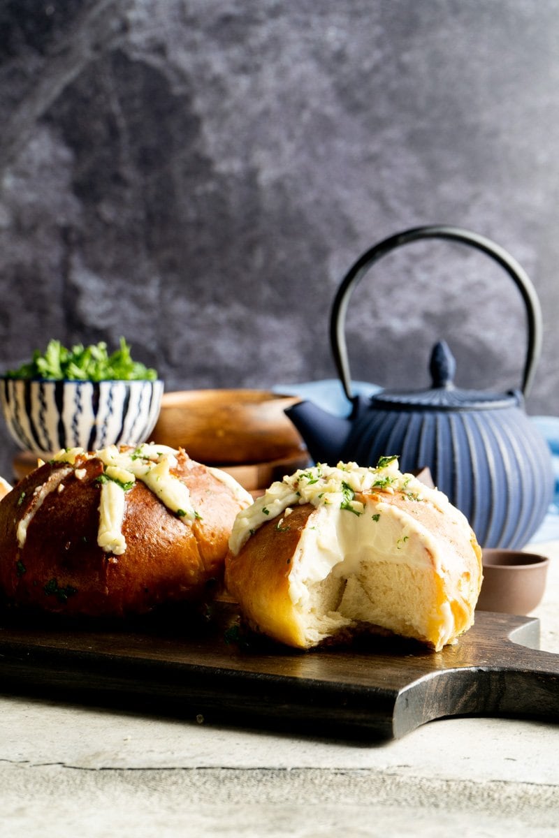 Korean Garlic Cream Cheese Bread on a cutting board with a slice removed.