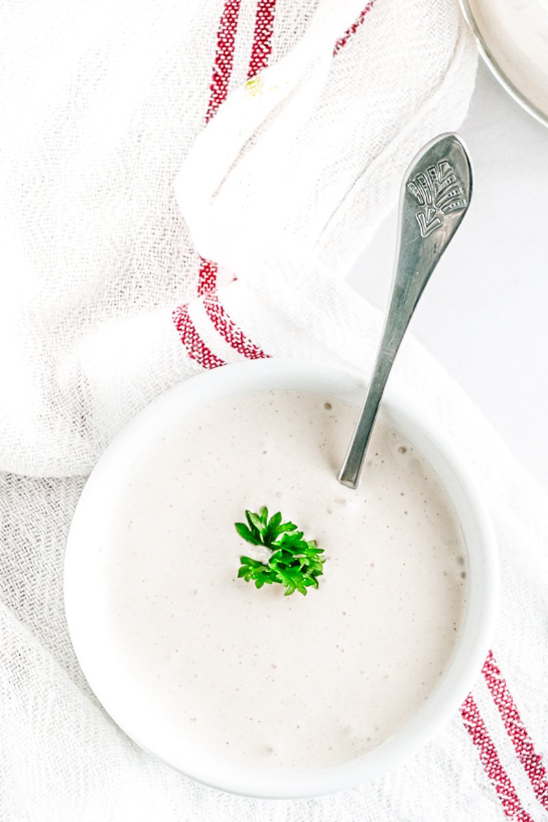 Egg free mayonnaise in a cup and a spoon for spreading.