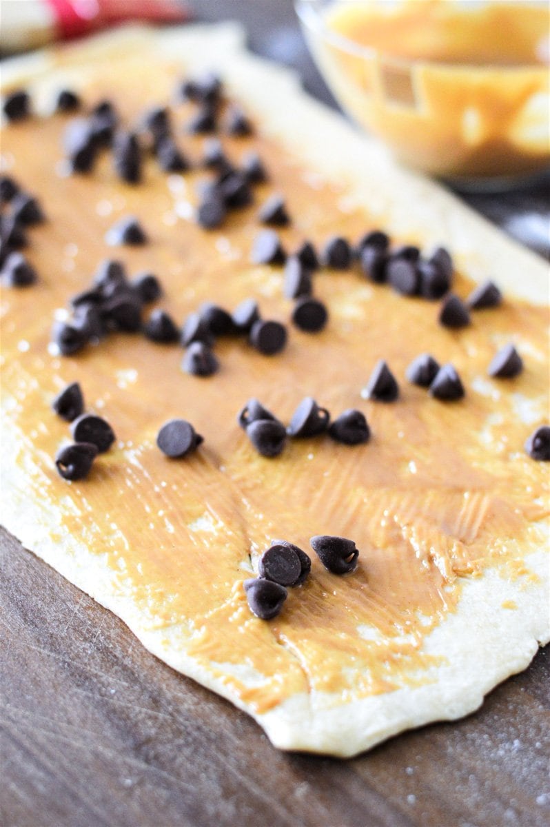 Crescent roll dough rolled out and topped with peanut butter and chocolate chips