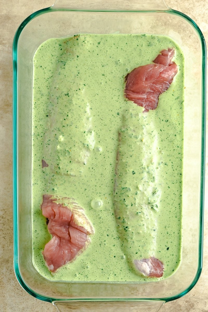 Porkloin in a dish covered with a mojo marinade