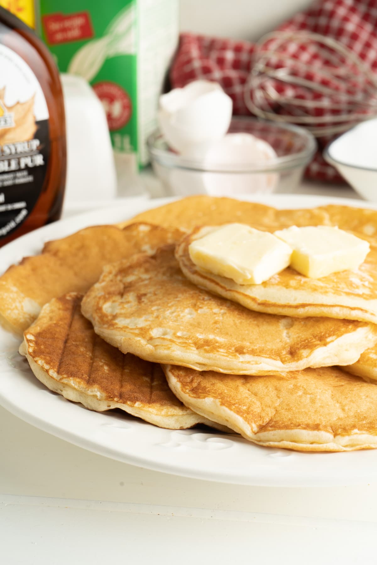 A plate of light and fluffy pancakes with butter.