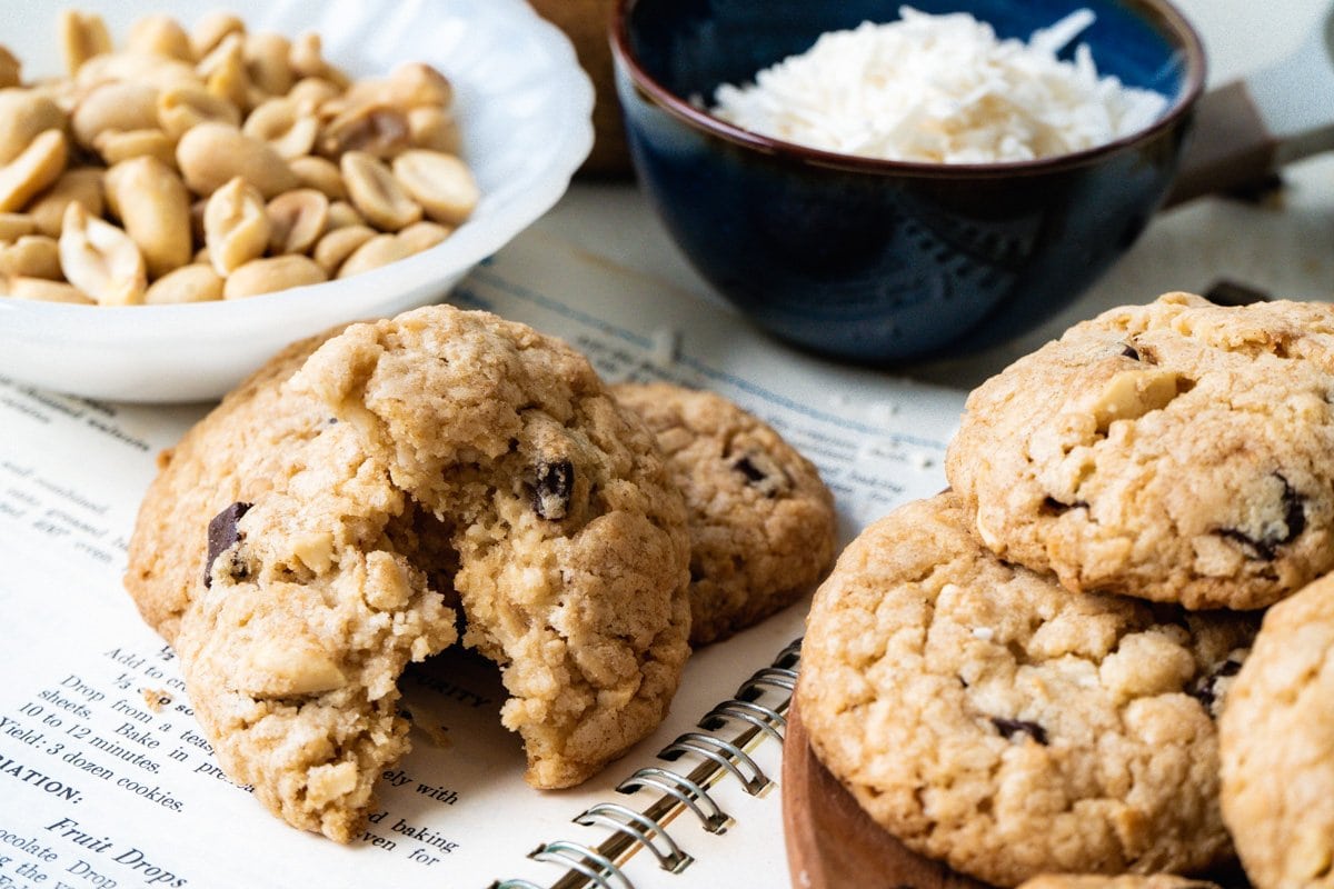 Oatmeal coconut chocolate chip cookies on a plate and on top of an open cookbook.