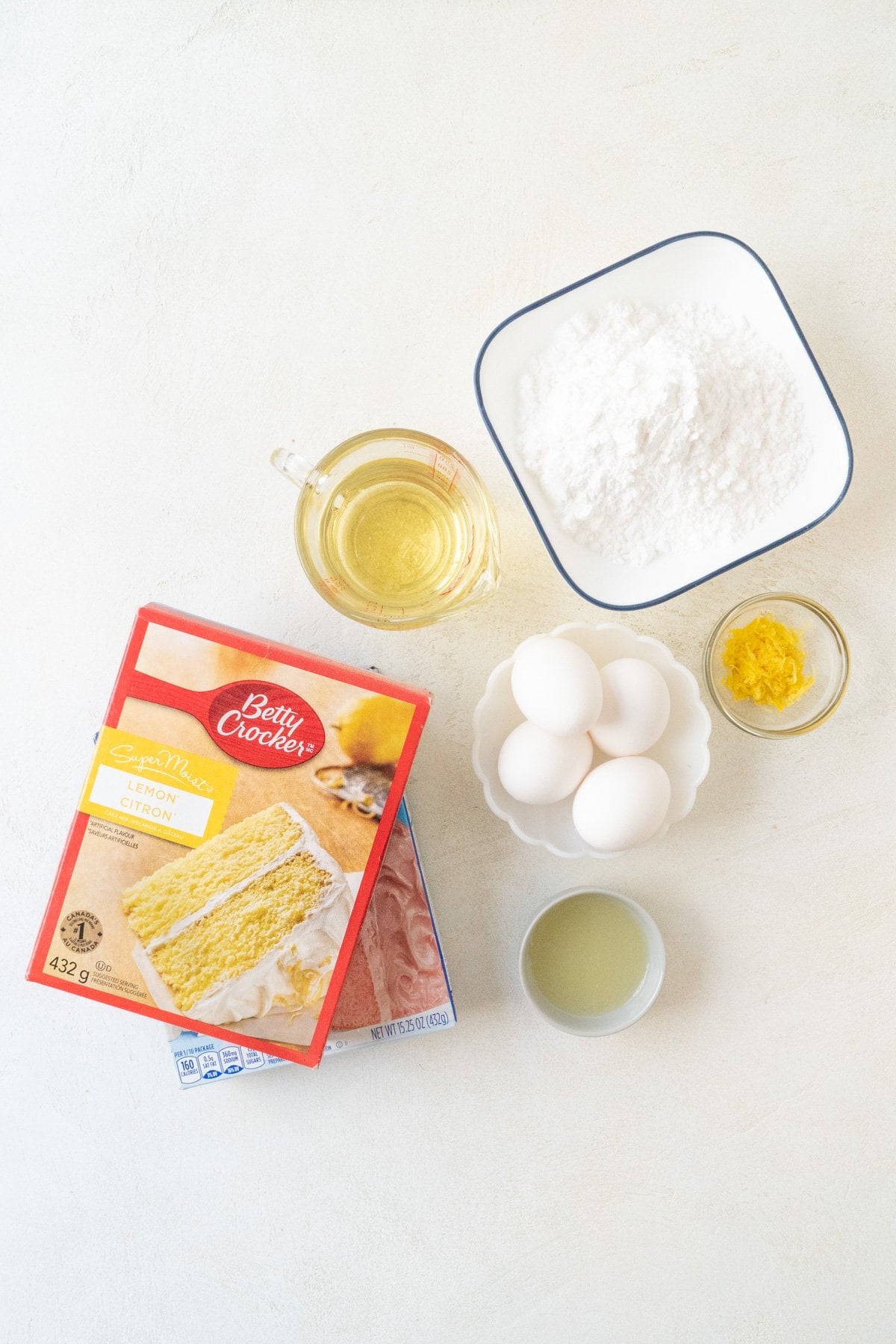 Ingredients for strawberry lemonade cookies - lemon and strawberry cake mix, eggs, oil, lemon zest, powdered sugar and lemon juice.