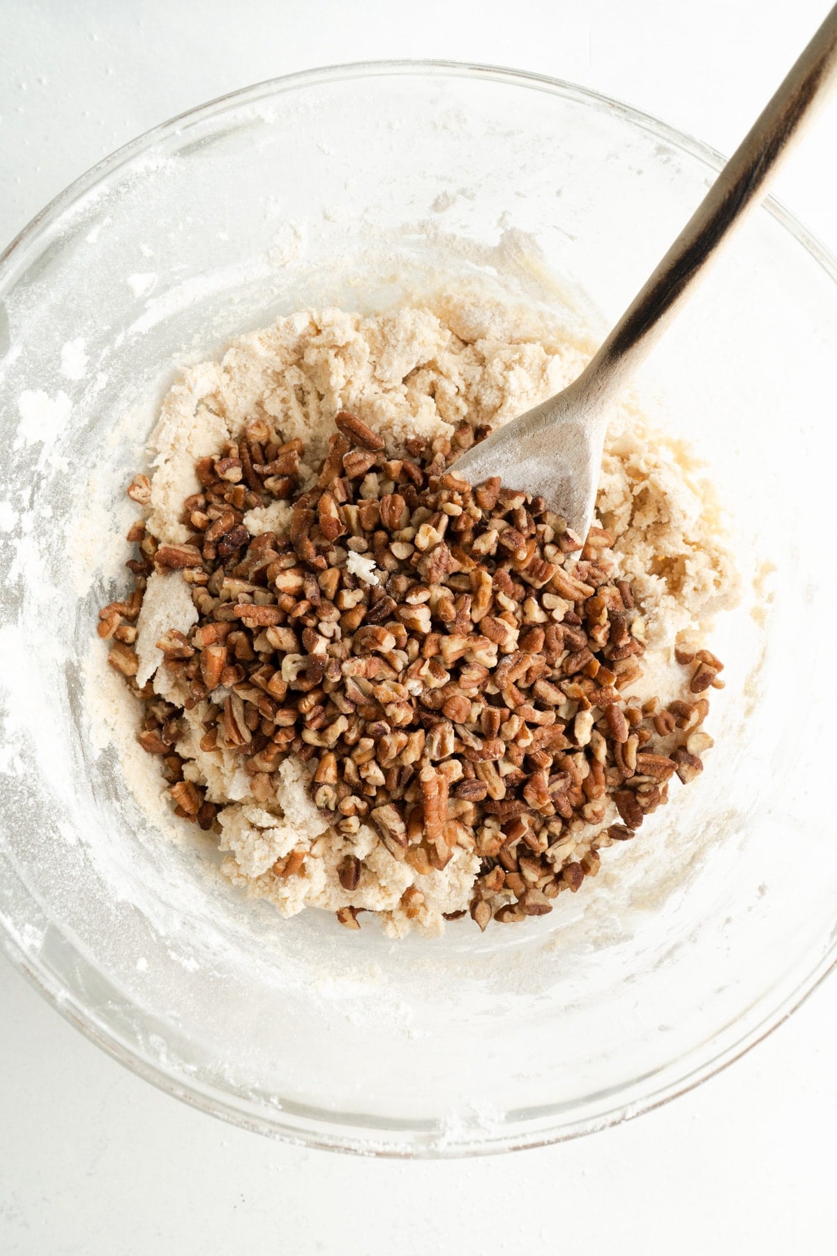Pecans added to a bowl of Danish Christmas cookie batter.