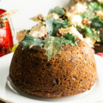 Christmas pudding on a plate decorated with holly.