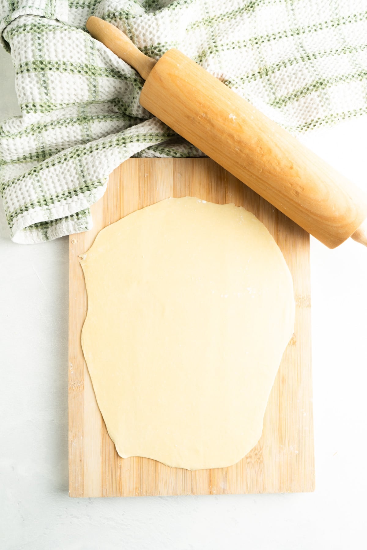 Faworki dough rolled out on a cutting board.