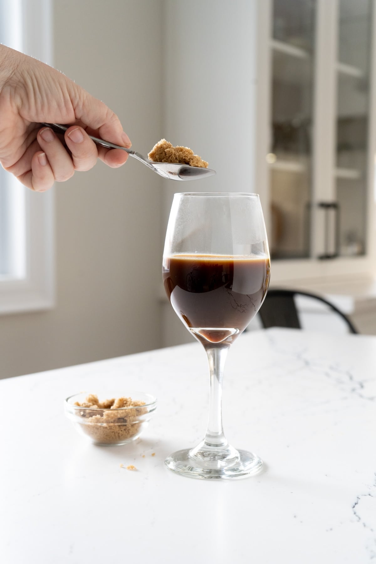 Adding brown sugar to coffee.