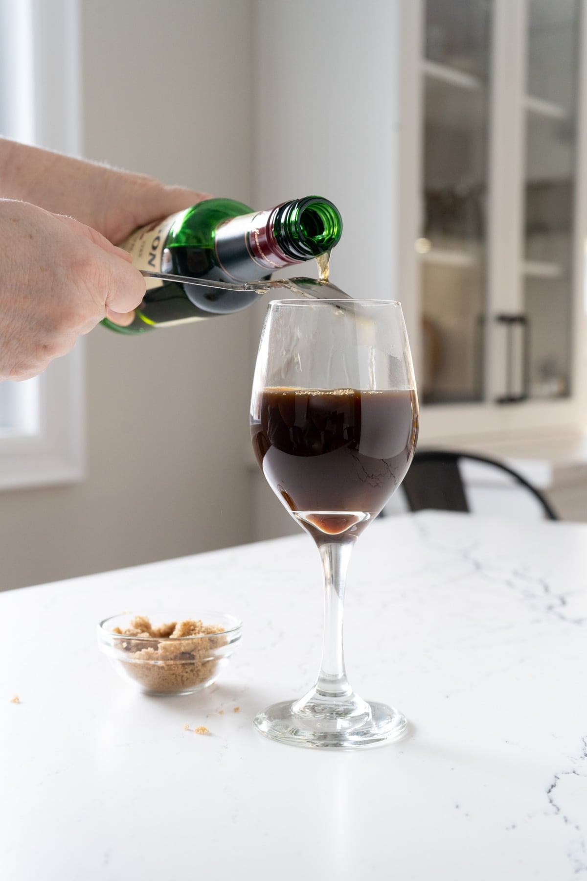 Pouring whisky over a hot spoon into coffee.