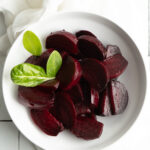 Roast beetroot in a white bowl.
