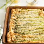 An asparagus puff pastry tart on a baking sheet.