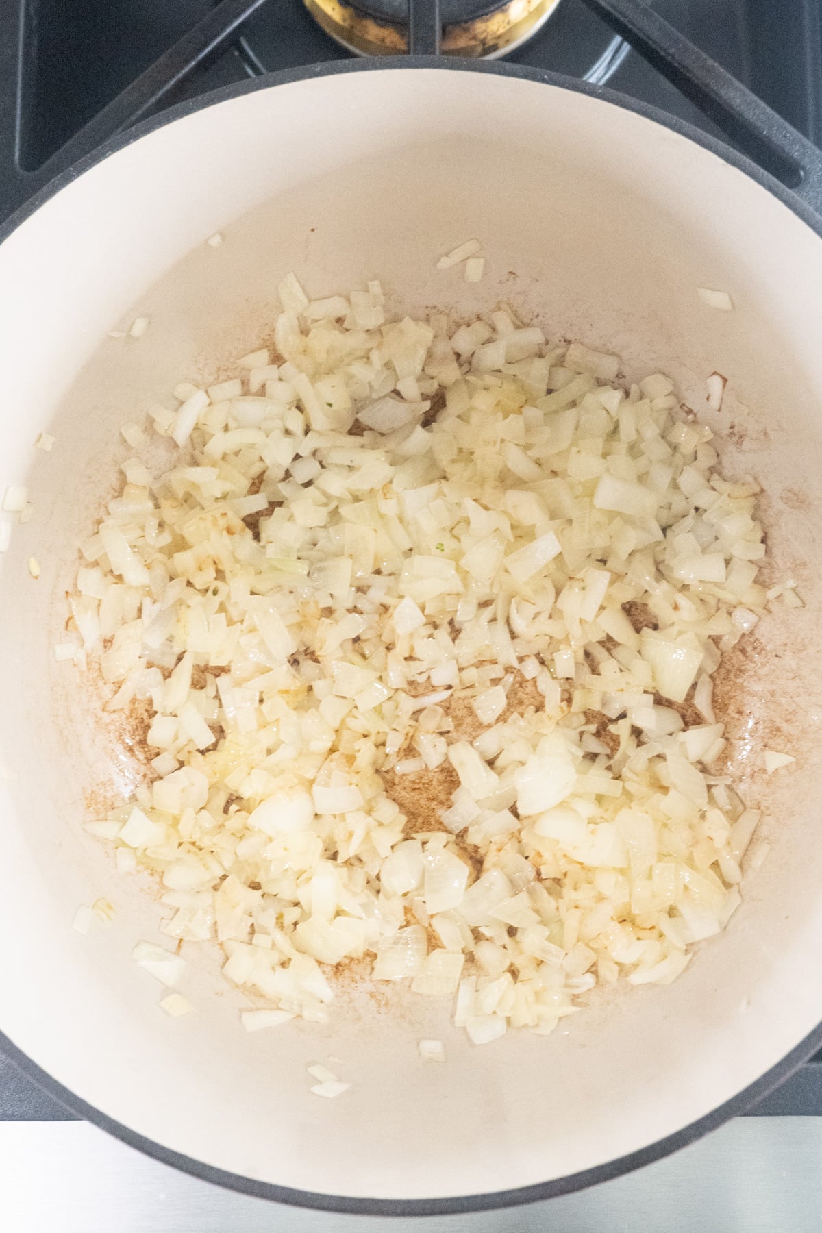 Onions and garlic sauteeing in a dutch oven.