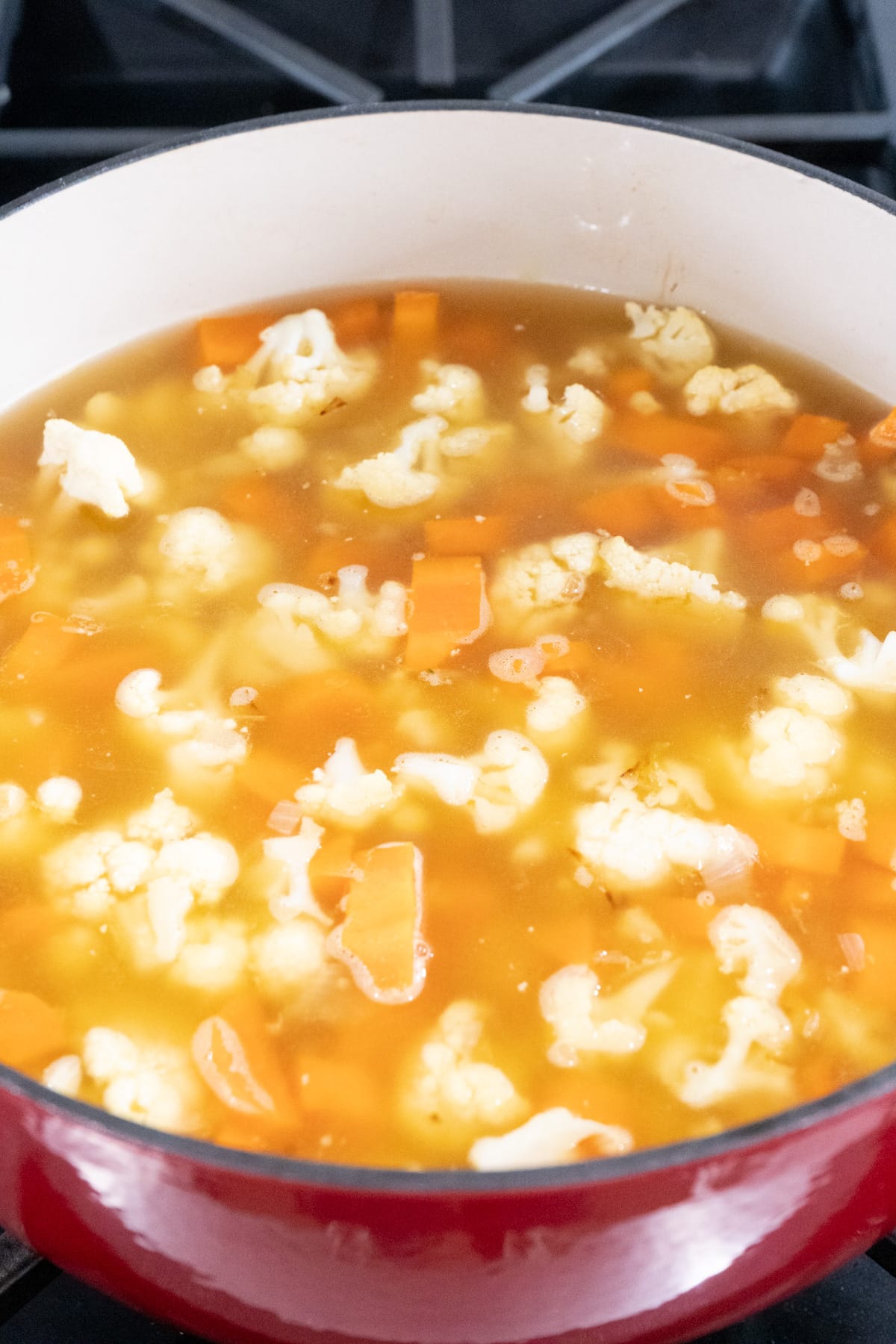 A pot filled with and easy carrot and cauliflower soup.