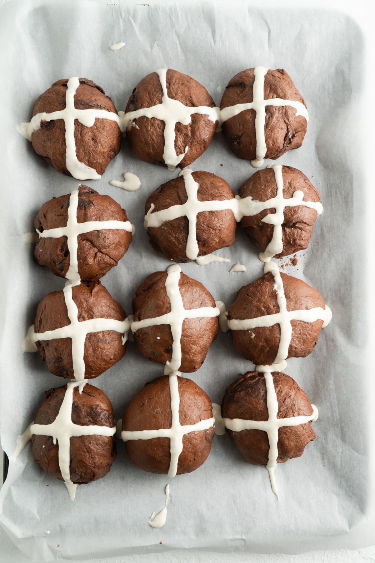 Adding crosses to chocolate chip easter buns.