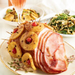 A honey baked spiral ham on a holiday table.