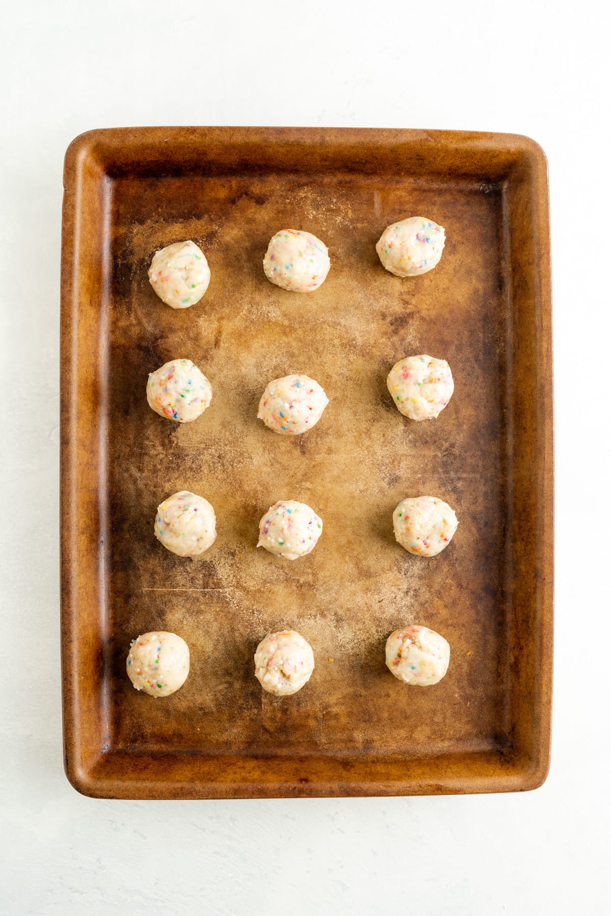 Vegan funfetti cookies rolled into balls for baking.