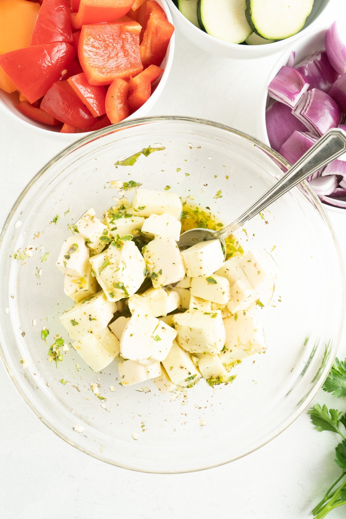 Halloumi being tossed in a vinaigrette marinade.