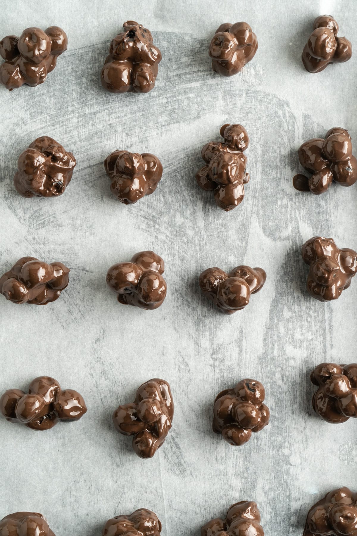 Chocolate blueberry clusters on a baking sheet.