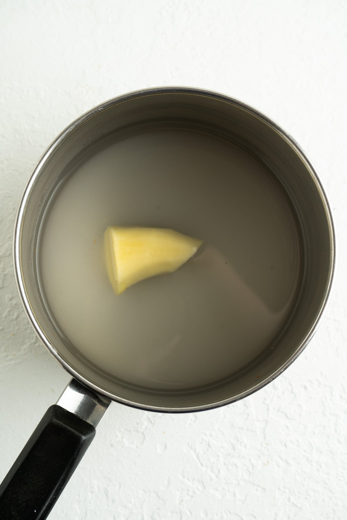 A pot of sugar, water and ginger.