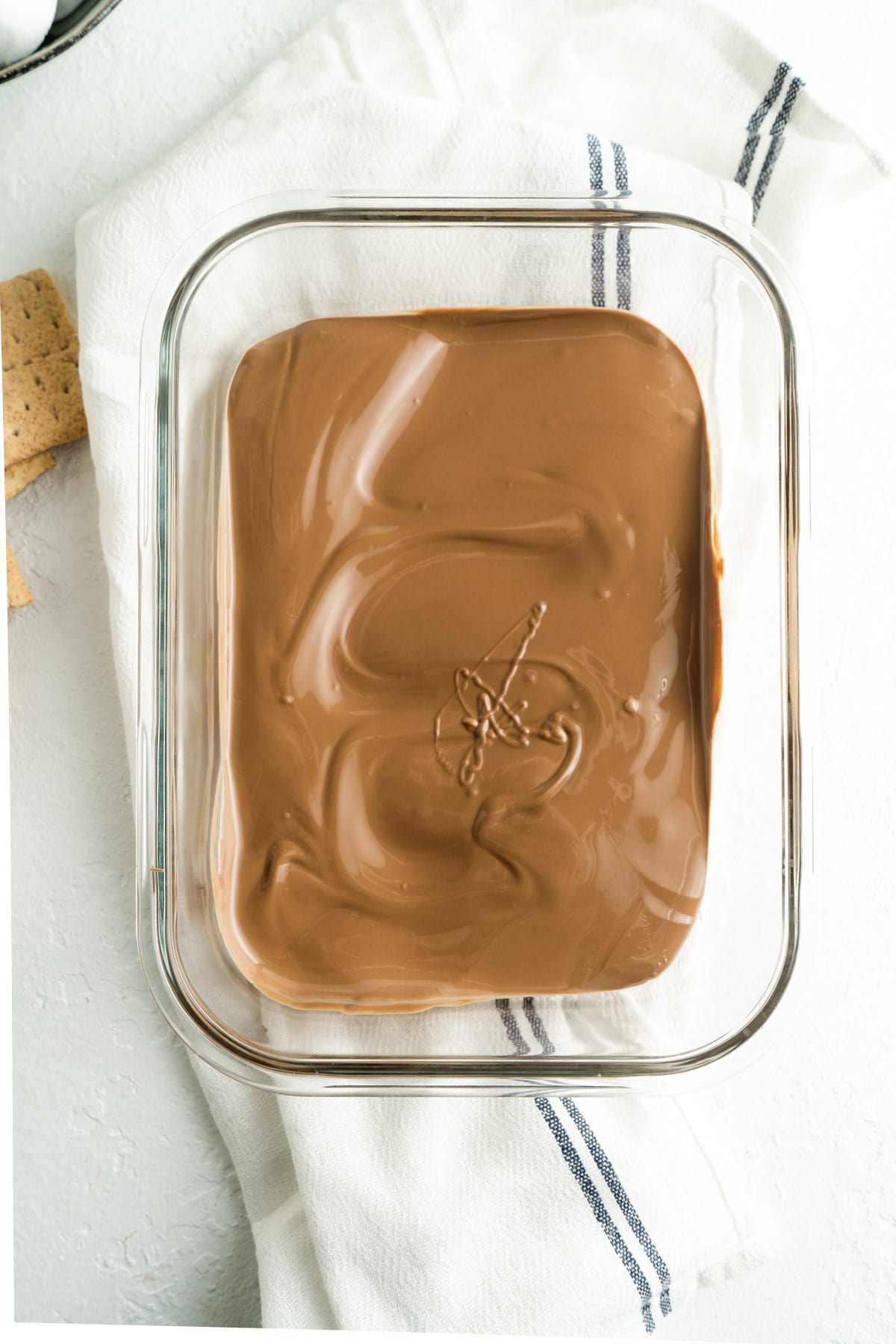 Melted chocolate in the bottom of a small glass casserole dish.