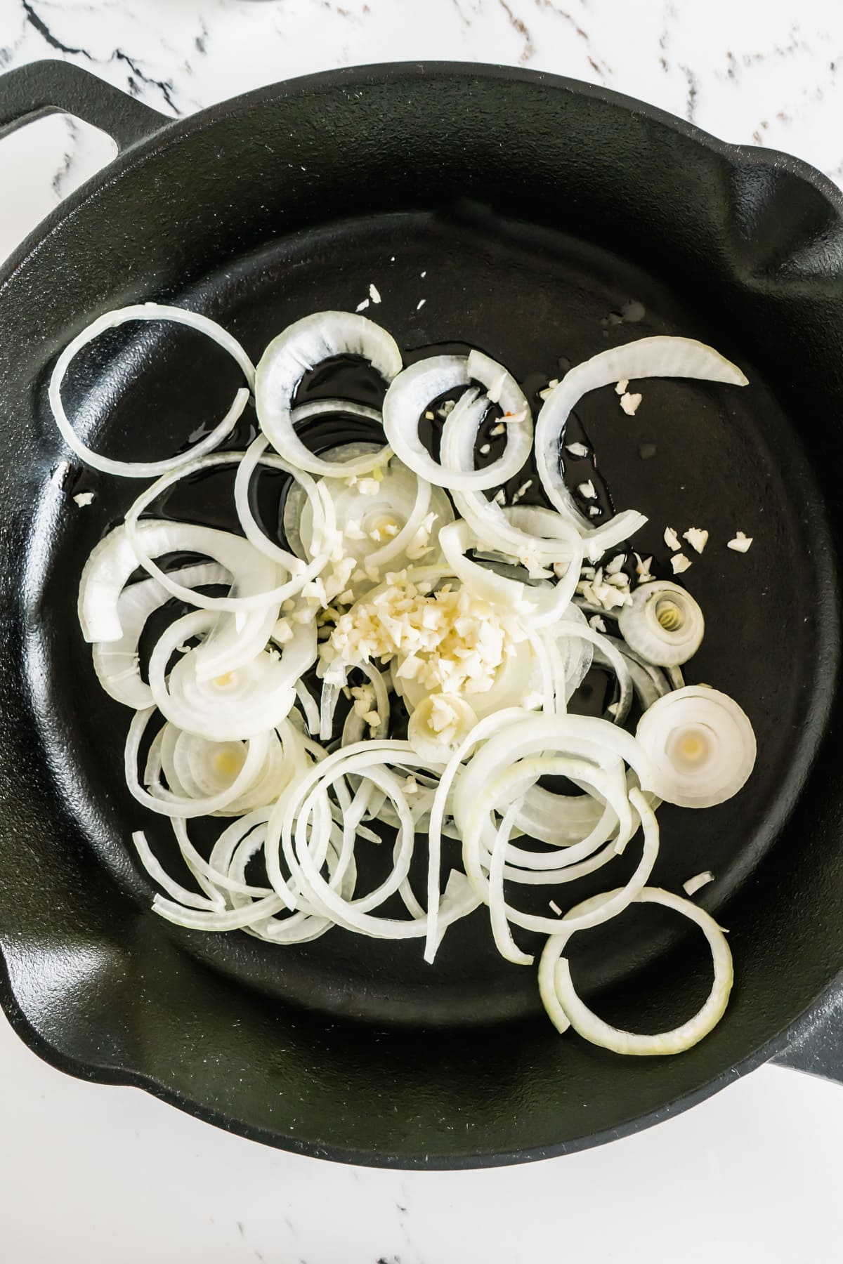 These Pan Fried Potatoes and Onions are a classic side dish that can be enjoyed for breakfast, brunch, or dinner. Sliced white onion in a skillet