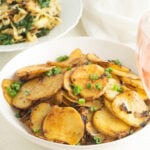 Fried potatoes and onions in a white bowl