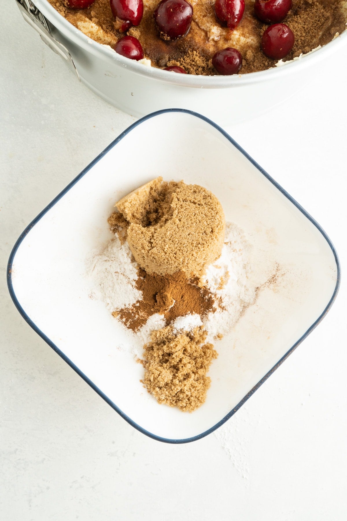 This Cherry Coffee Cake features light, tender layers of cake, a sweet cinnamon swirl, fresh cherries, and an irresistible crumb topping. Crumb topping ingredients in a bowl