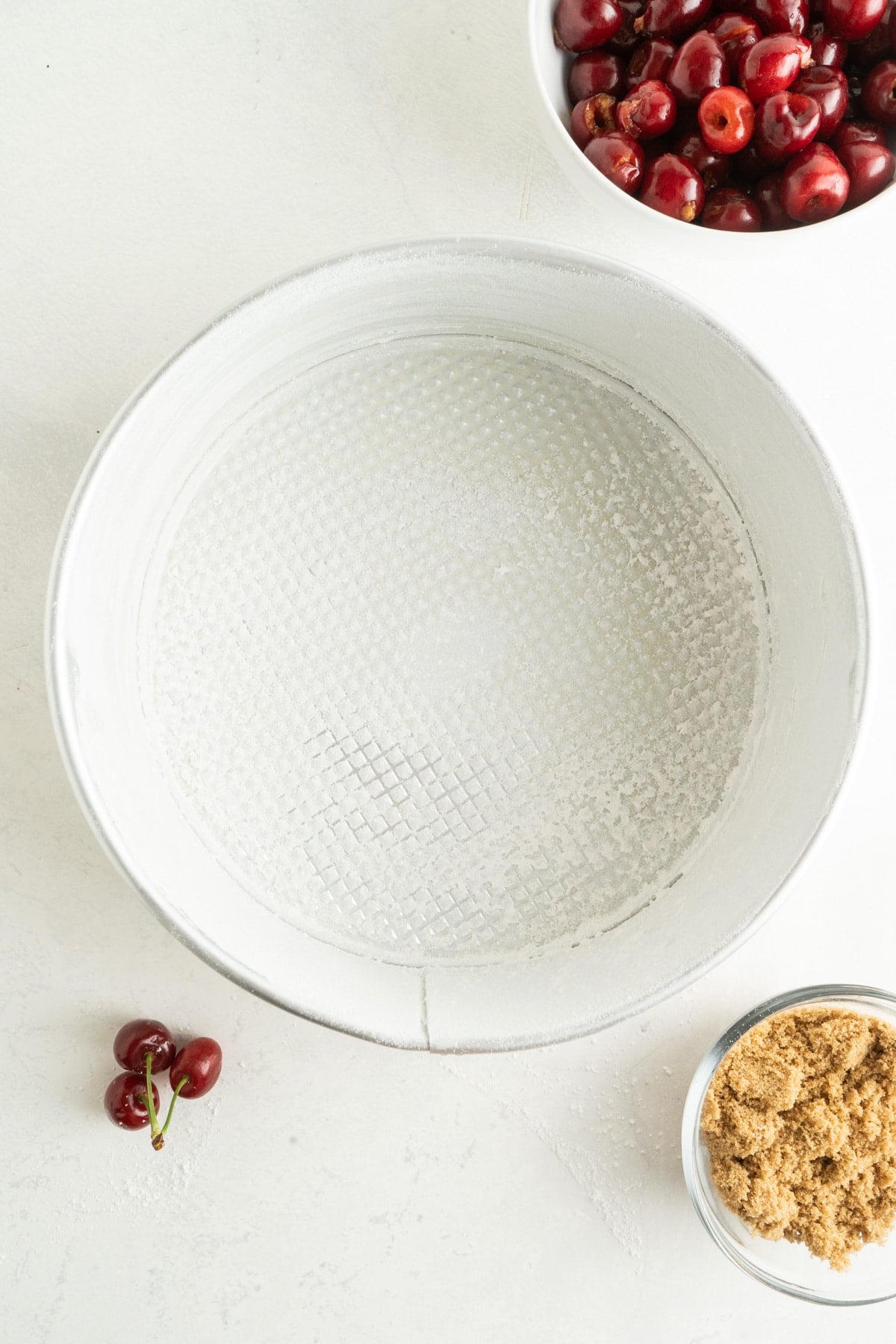This Cherry Coffee Cake features light, tender layers of cake, a sweet cinnamon swirl, fresh cherries, and an irresistible crumb topping. A round springform pan dusted with flour