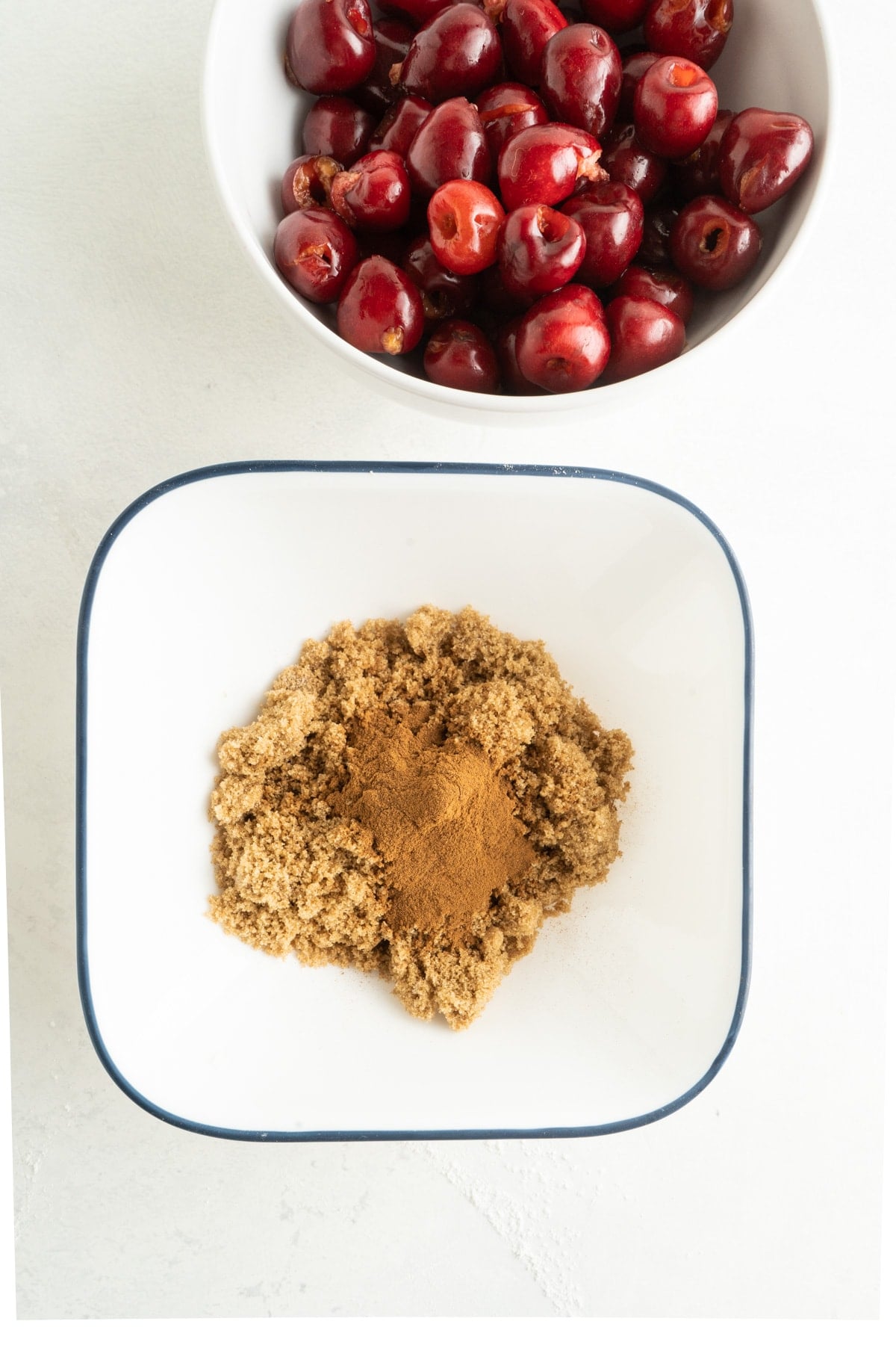 This Cherry Coffee Cake features light, tender layers of cake, a sweet cinnamon swirl, fresh cherries, and an irresistible crumb topping. Cinnamon sugar ingredients in a bowl