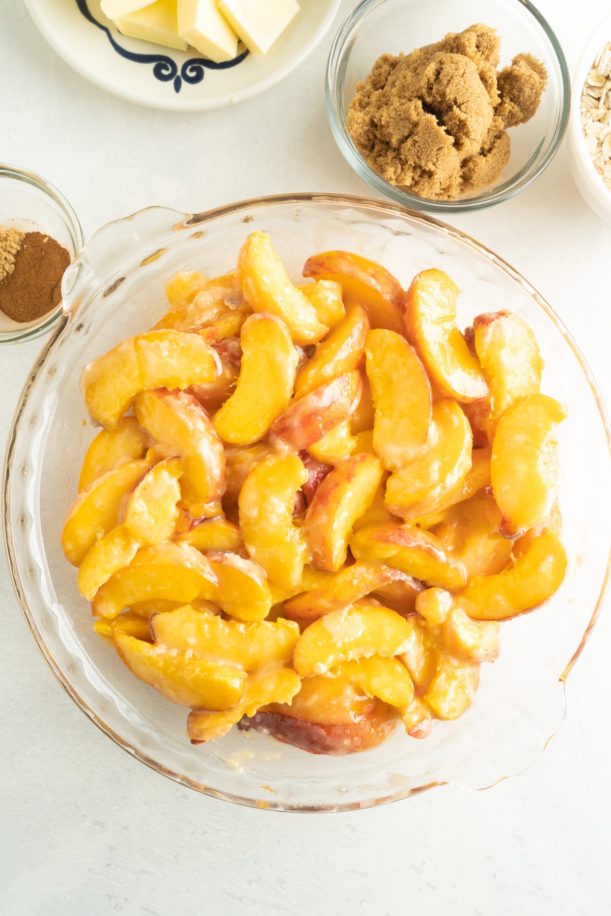 This Easy Peach Crumble features a fresh peach filling topped with a brown sugar and oat crumb topping. Enjoy with a scoop of ice cream! Peach filling in a pie dish
