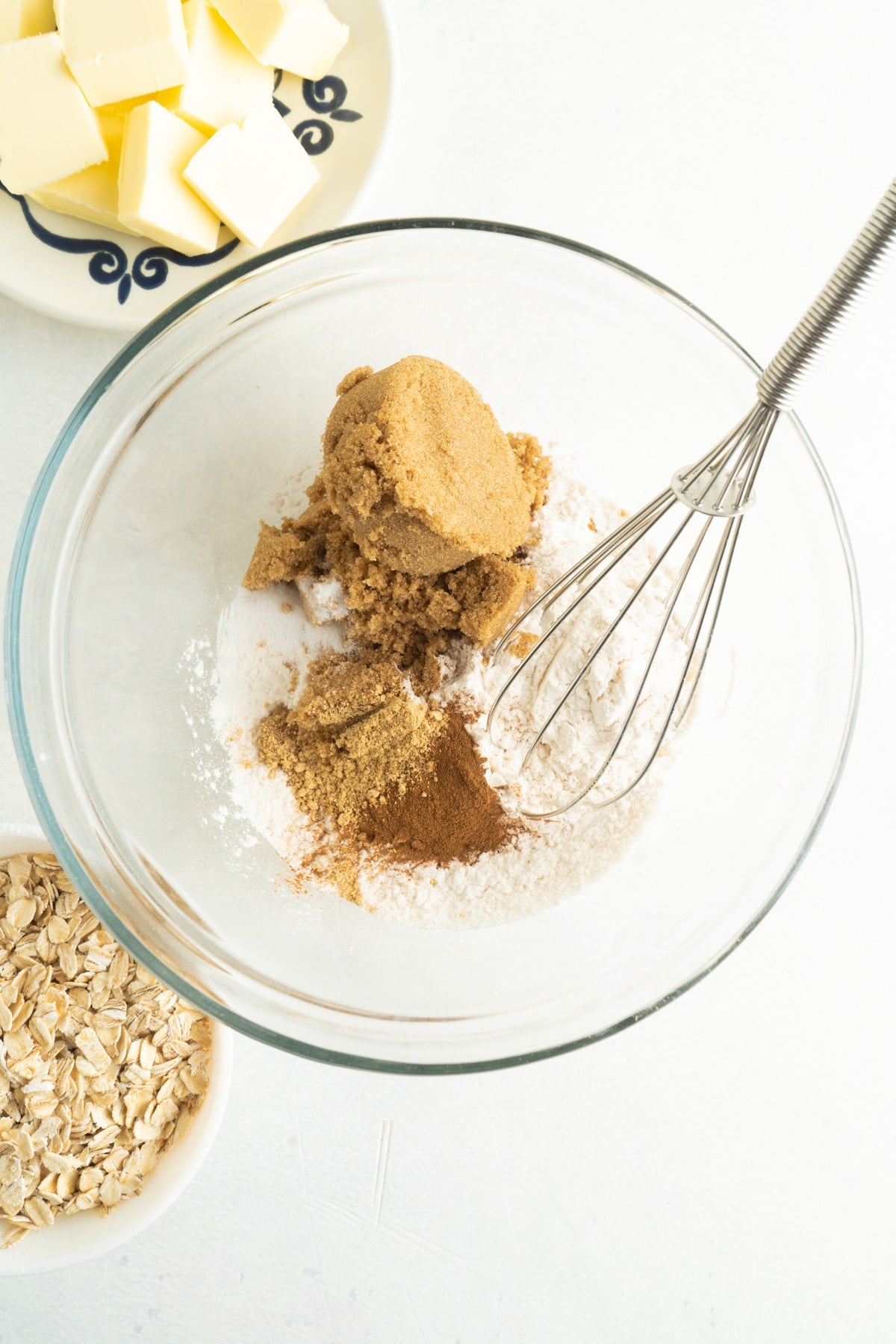 This Easy Peach Crumble features a fresh peach filling topped with a brown sugar and oat crumb topping. Enjoy with a scoop of ice cream! A whisk stirring crumble topping ingredients