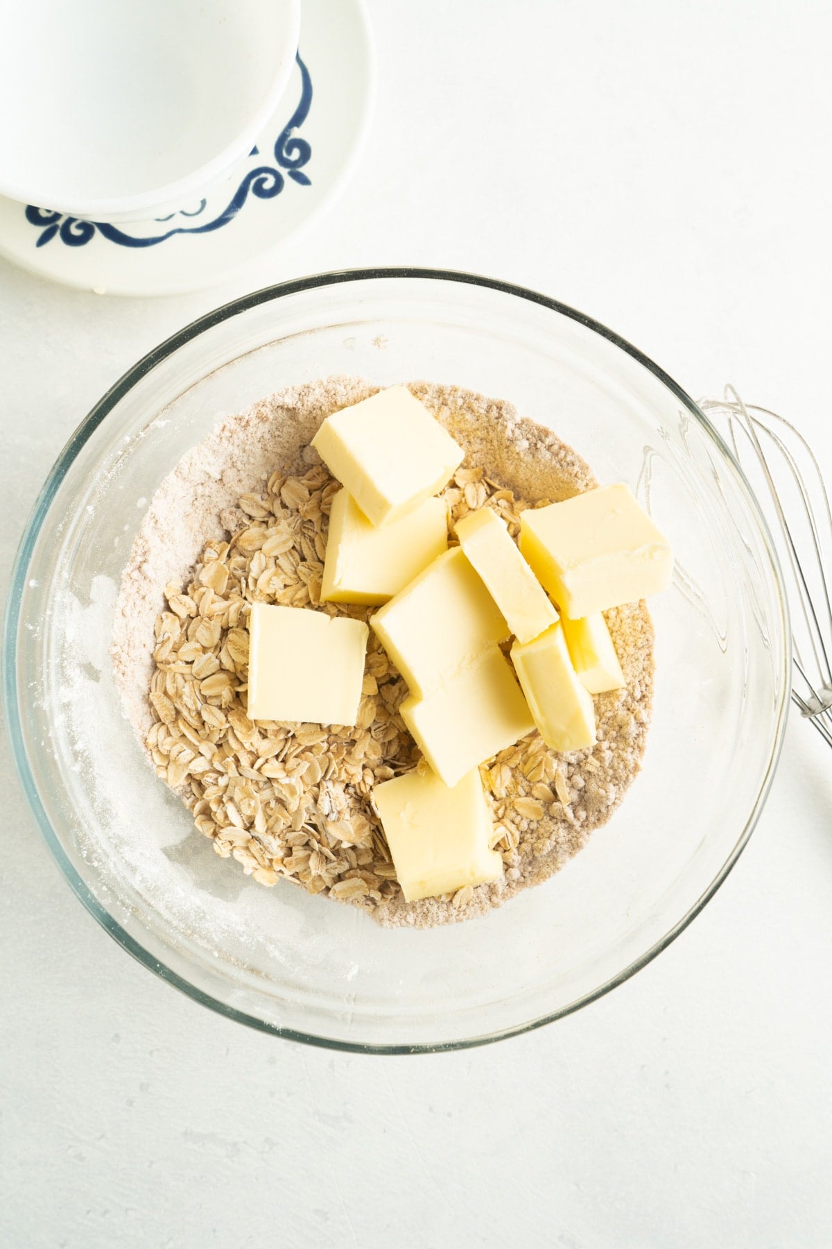 This Easy Peach Crumble features a fresh peach filling topped with a brown sugar and oat crumb topping. Enjoy with a scoop of ice cream! Cubes of butter in a bowl with crumb topping ingredients