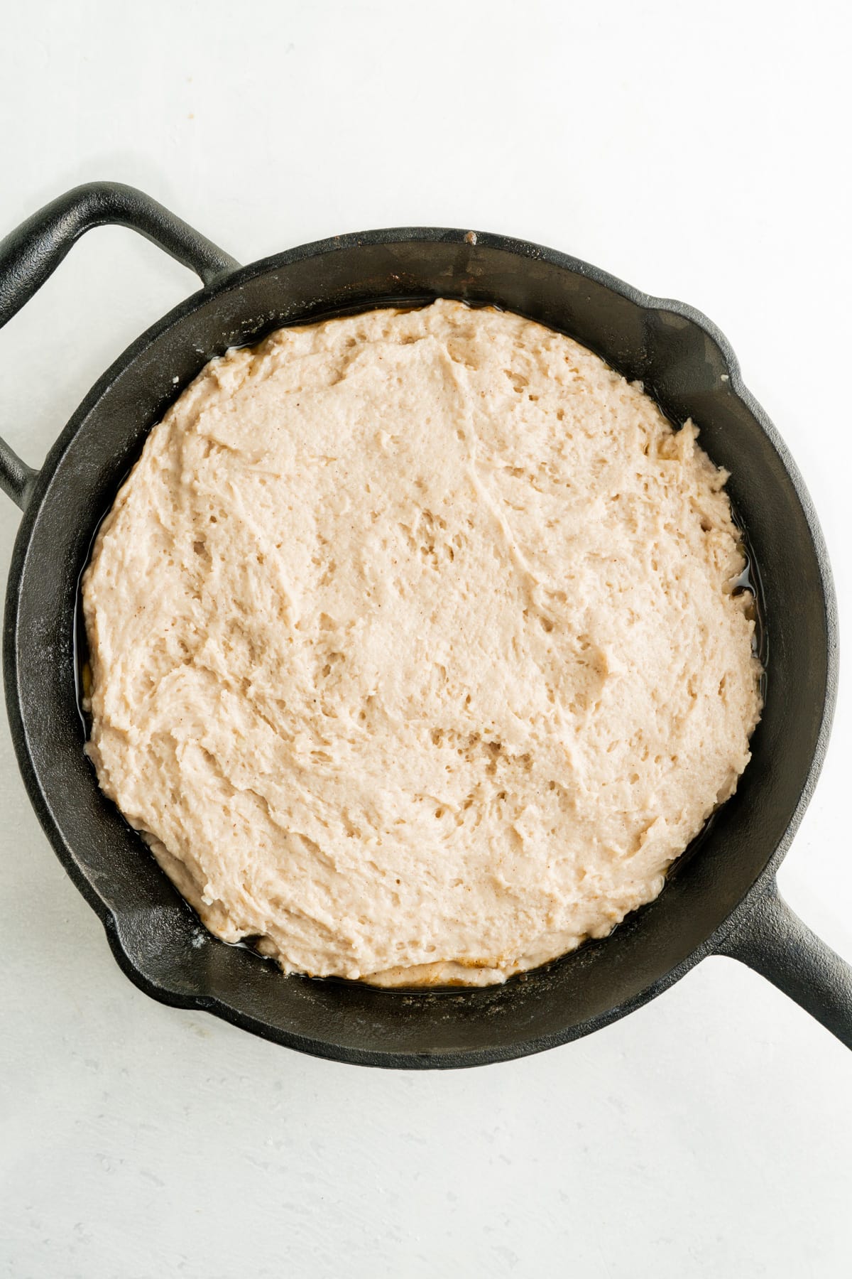 This Pear Upside Down Cake Recipe features a caramelized pear and brown sugar topping over a sweet, tender cake. Upside down cake batter in a skillet