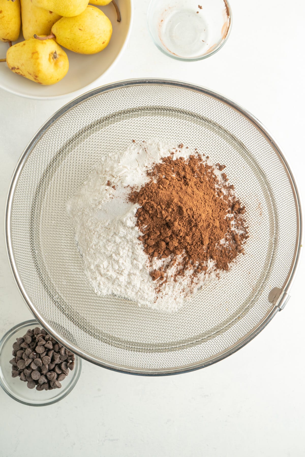 Dry cake ingredients in a sieve over a bowl