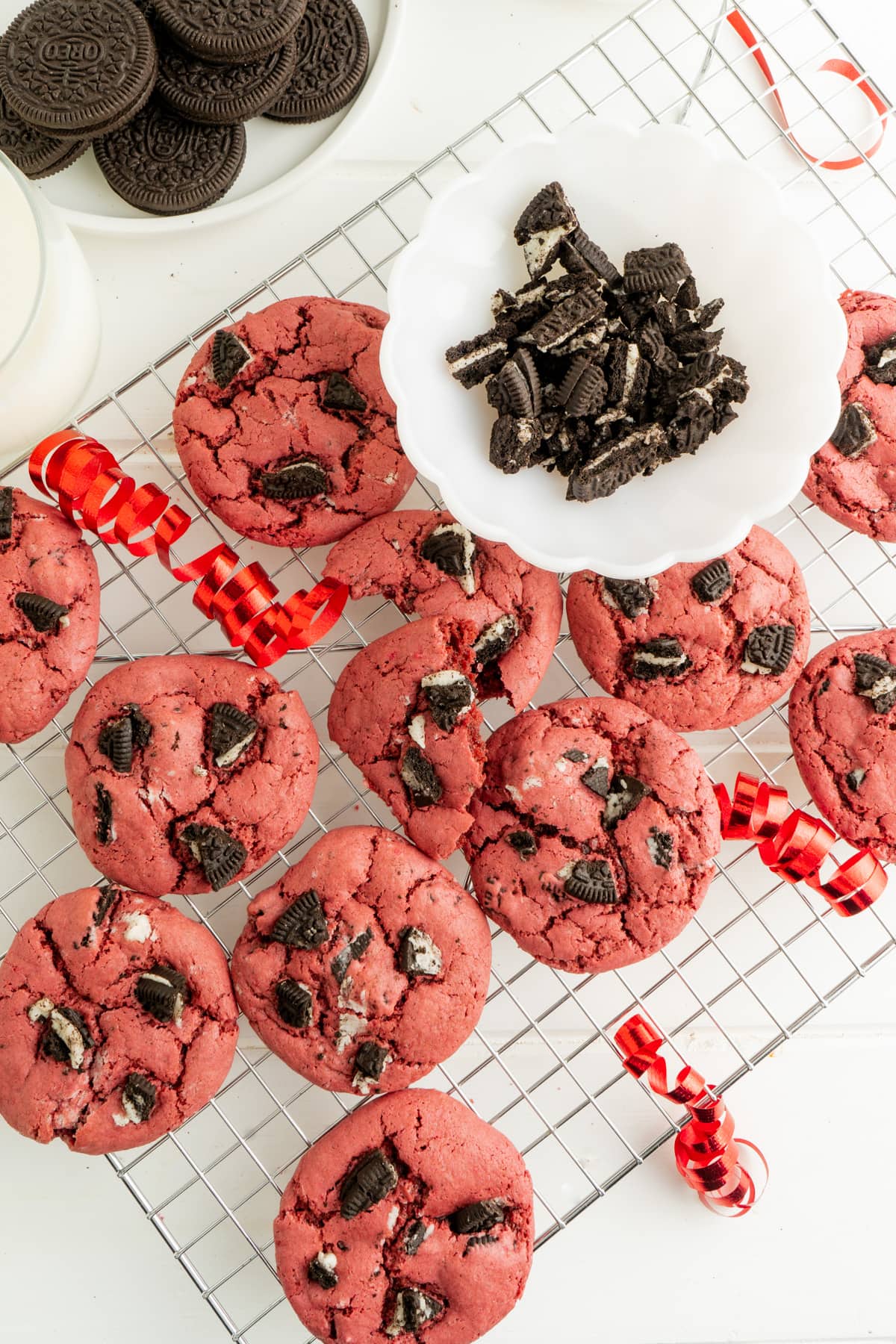 A Red velvet cake mix cookie recipe on a cooling rack after baking with some crumbled Oreos.