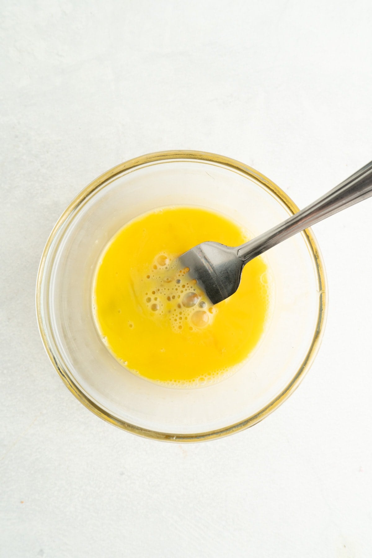 Made with just 4 ingredients in less than 10 minutes, this Pastina Soup with Egg is a classic Italian recipe the entire family will love. A whisked egg in a small bowl.