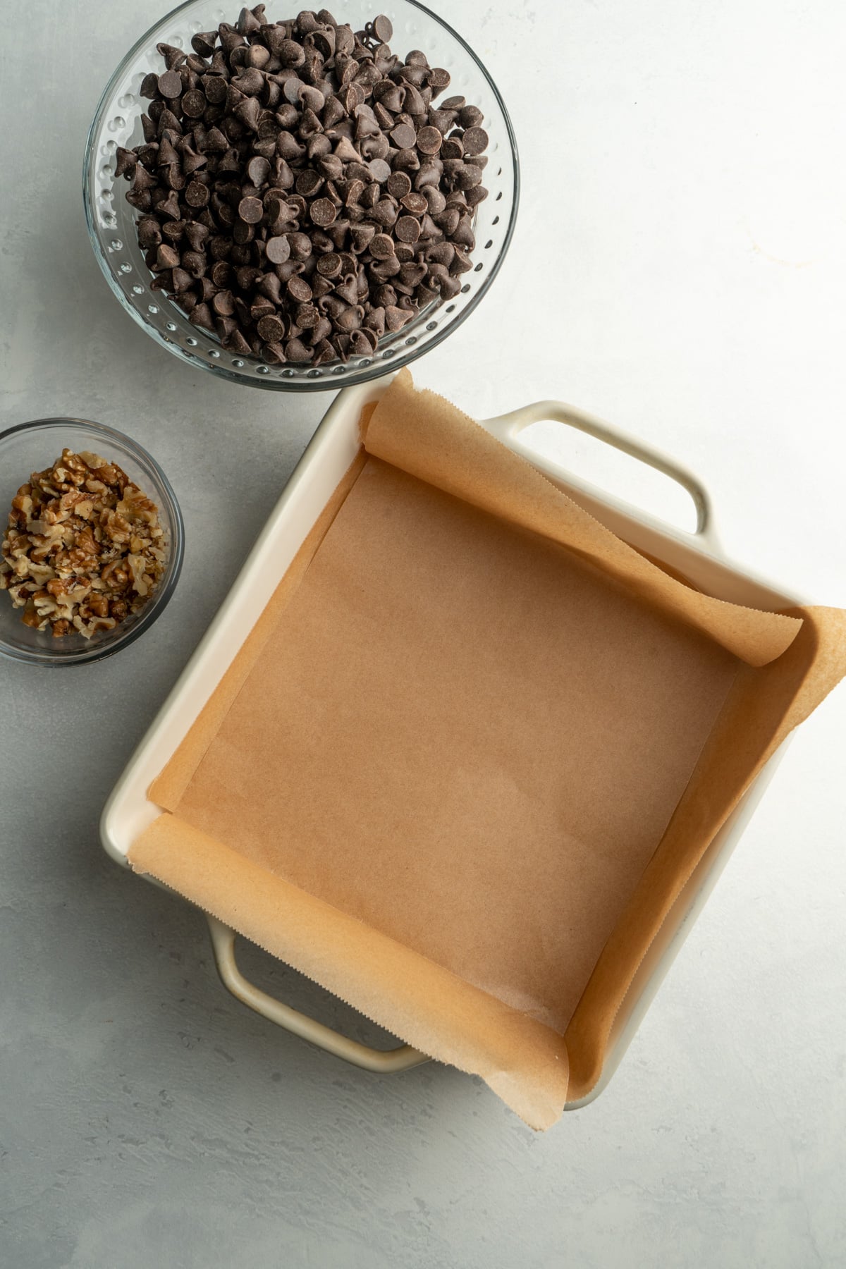A square pan lined with parchment paper.