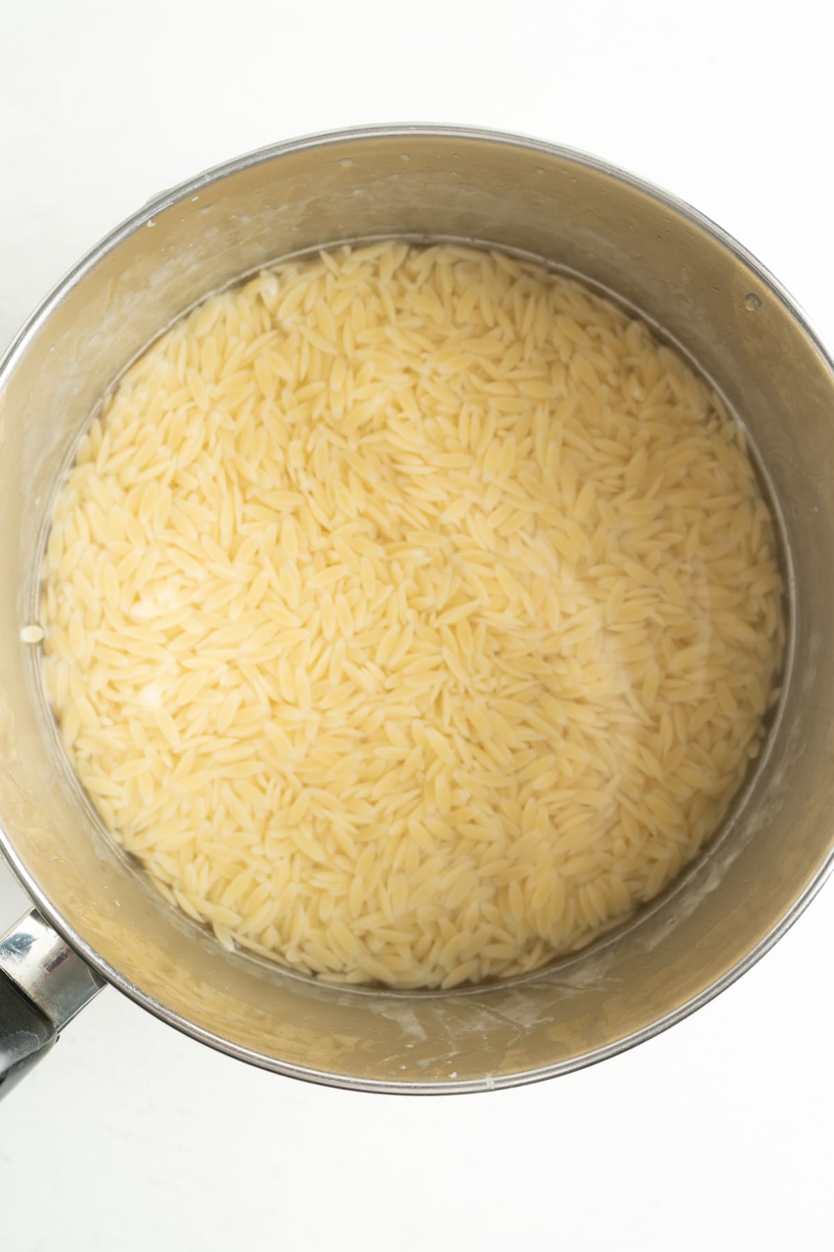 Orzo pasta cooking in a pot.