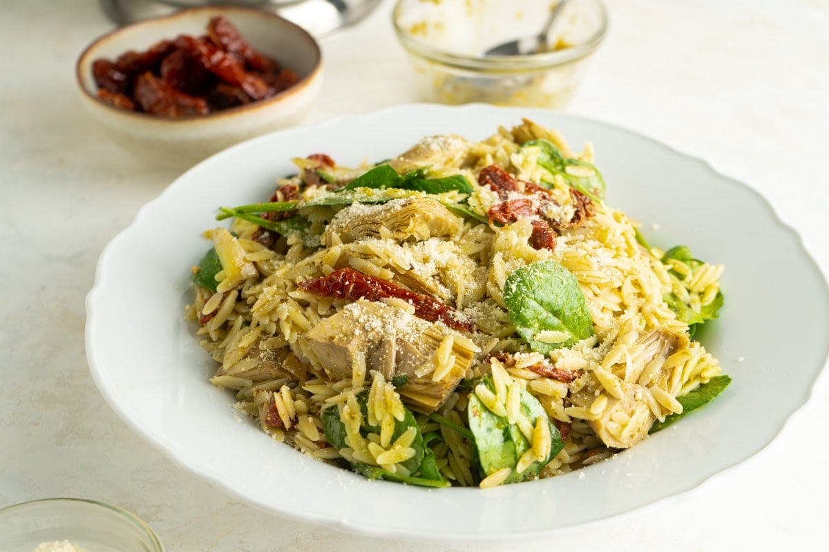 An Artichocke and Pesto Salad made with orzo pasta in a bowl.