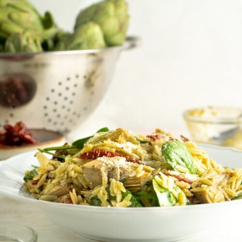 A recipe for an orzo salad in a bowl on a table.