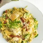 Pinterest pin of a orzo salad with artichokes and pesto.