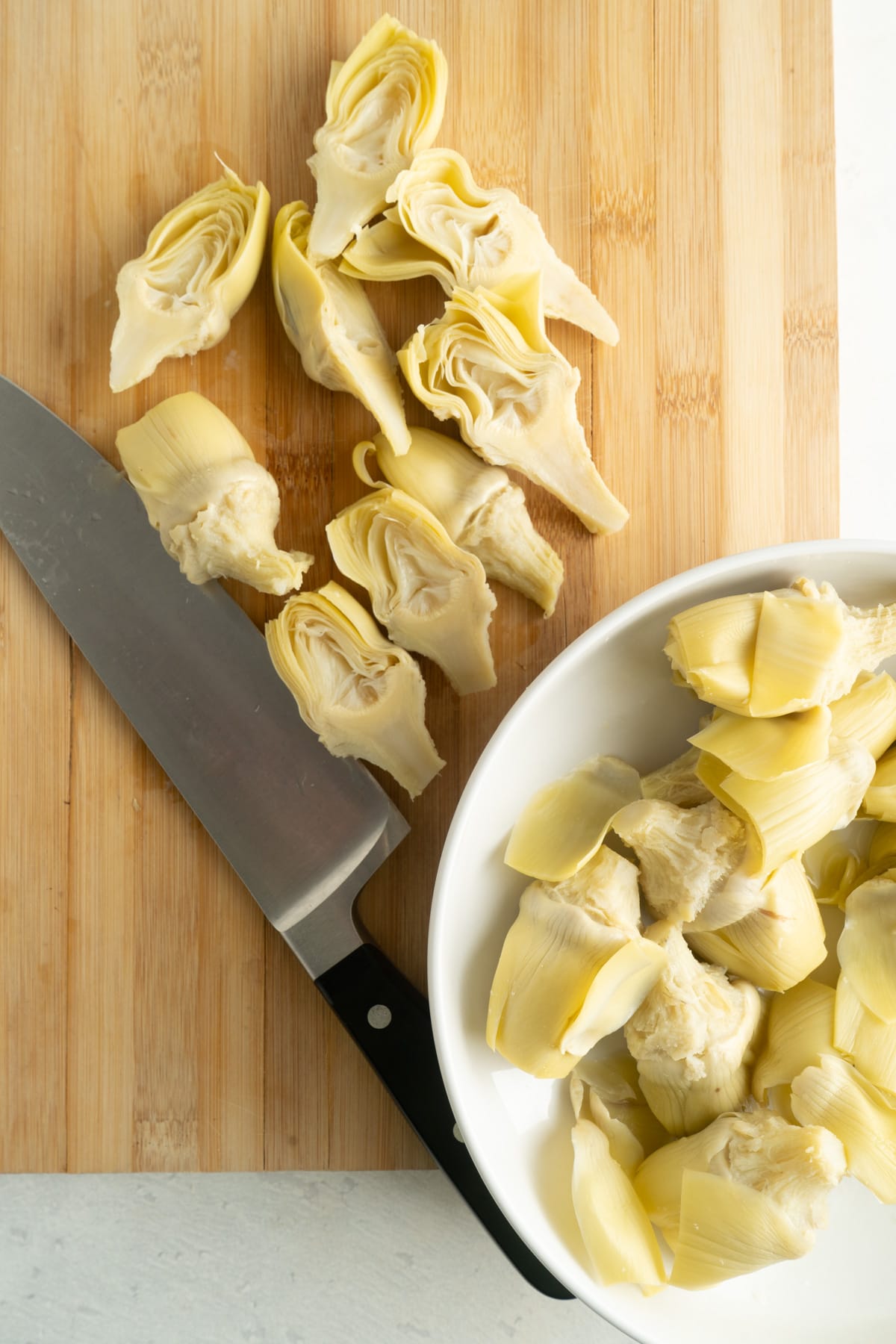 Artichoke hearts being cut in half.
