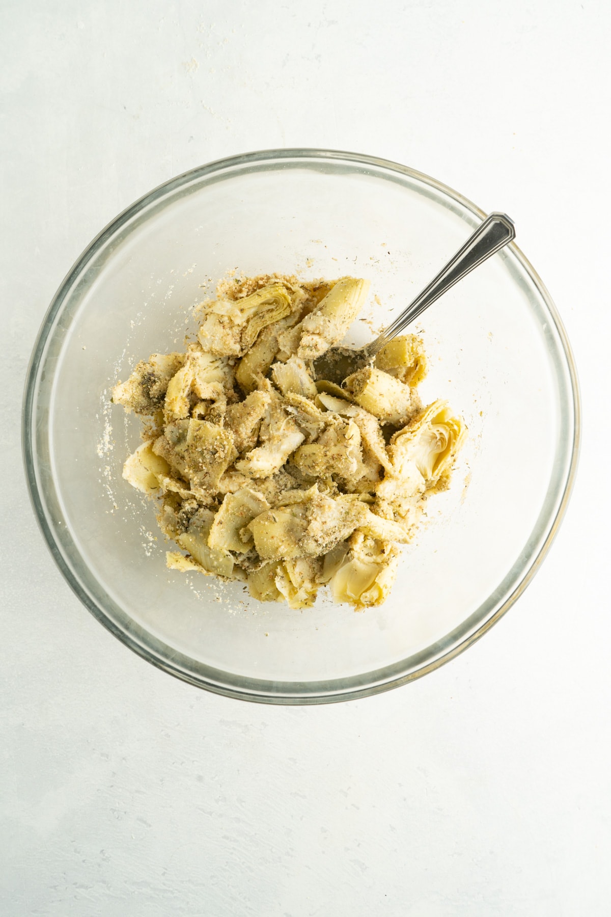 A bowl of ingredients for air fried artichoke hearts.